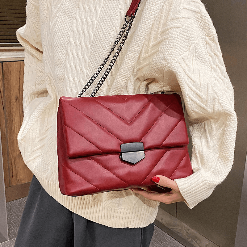 model carrying red embossed handbag