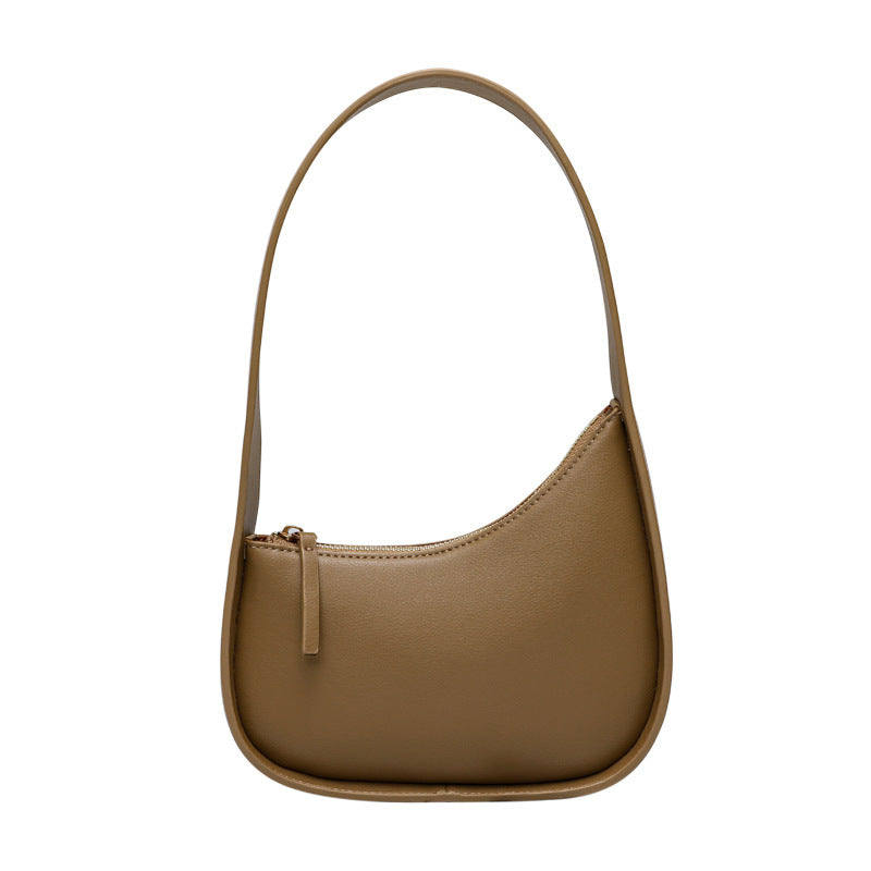 A brown leather shoulder bag with a half moon design, featuring a wide shoulder strap and a soft handle.
