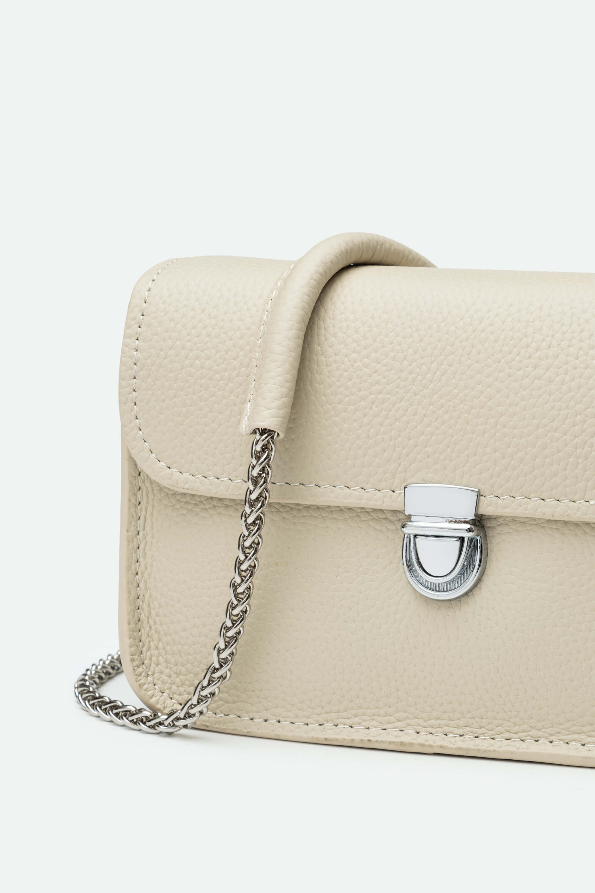 Beige handbag with a chain detail on a white background