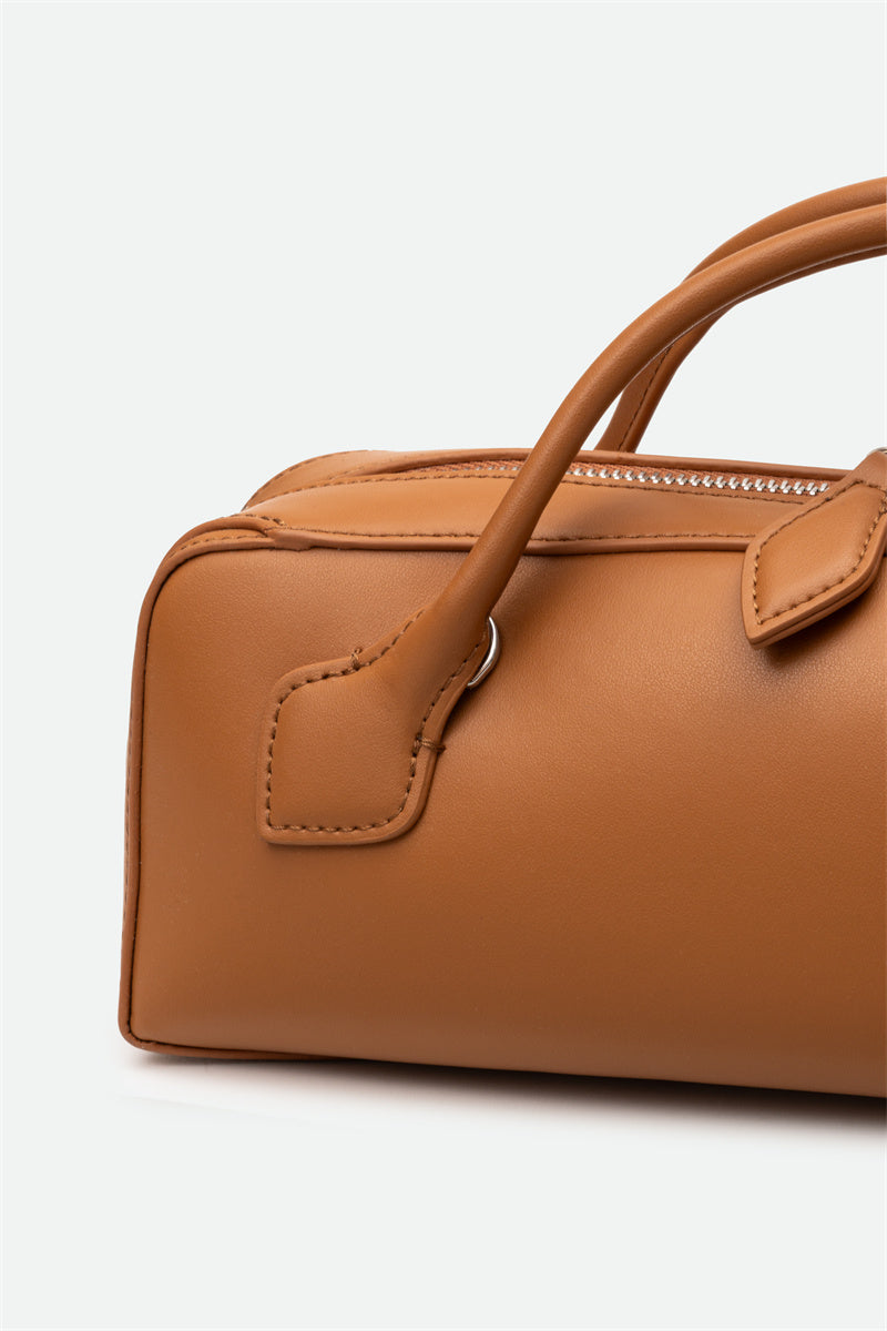 Brown handbag with a handle on a white background