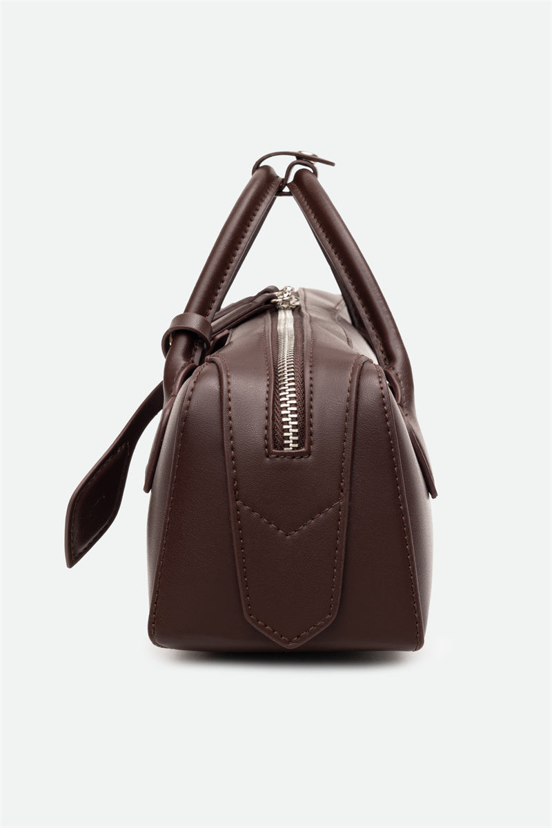 Brown leather handbag with a zipper on a white background