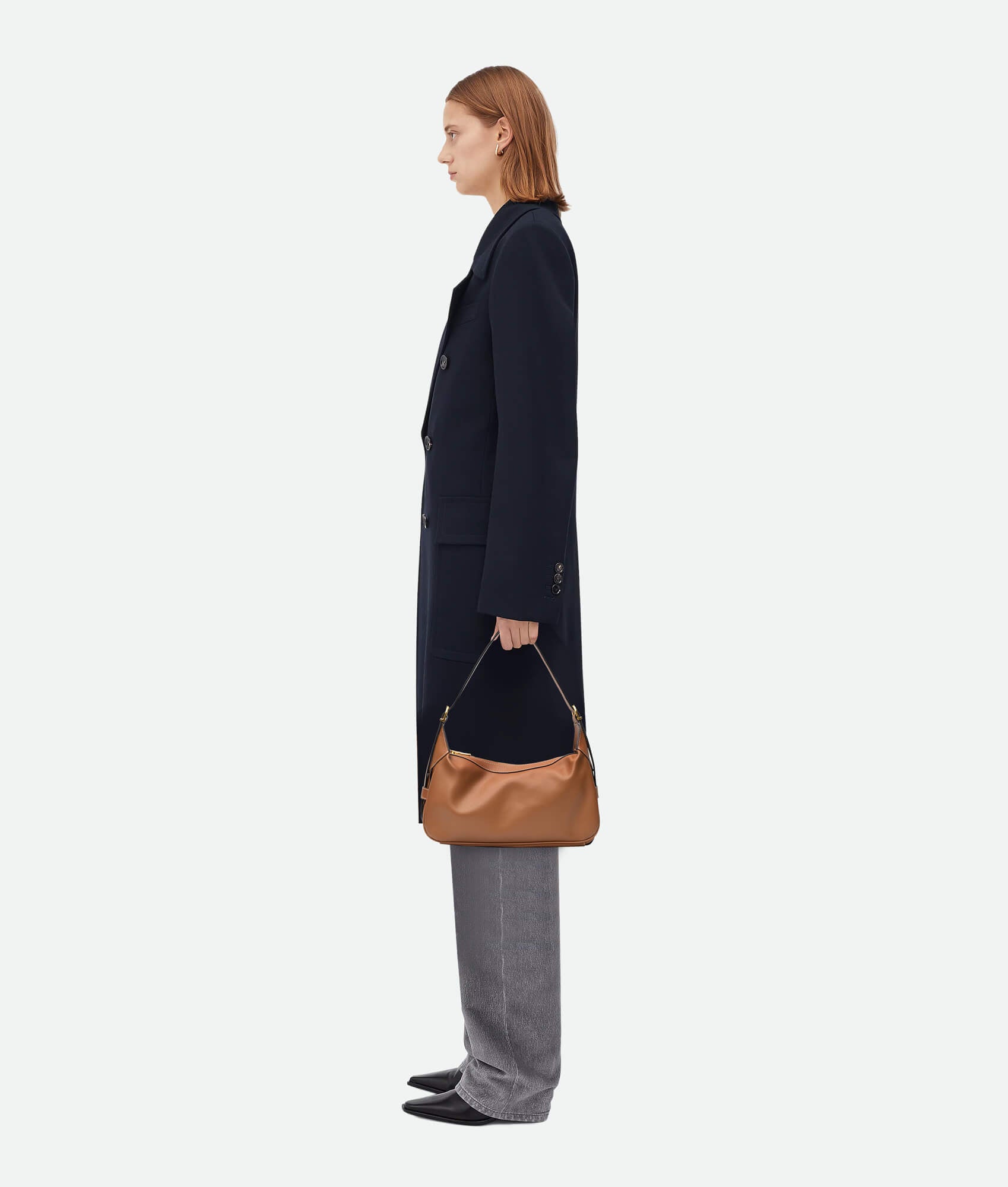 Model wearing brown leather handbag