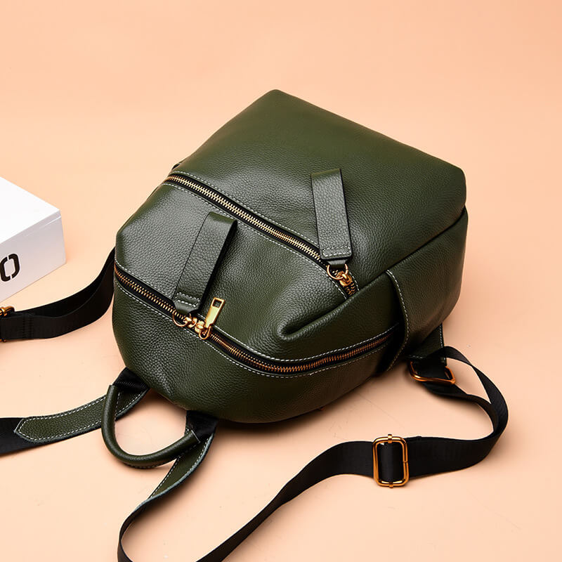 Green leather backpack with gold-tone hardware, featuring a front zipper pocket and adjustable straps.