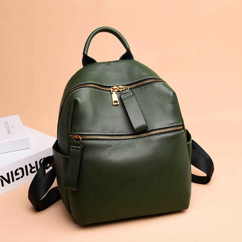 Green leather backpack with gold-tone hardware, featuring a front zipper pocket and adjustable straps.