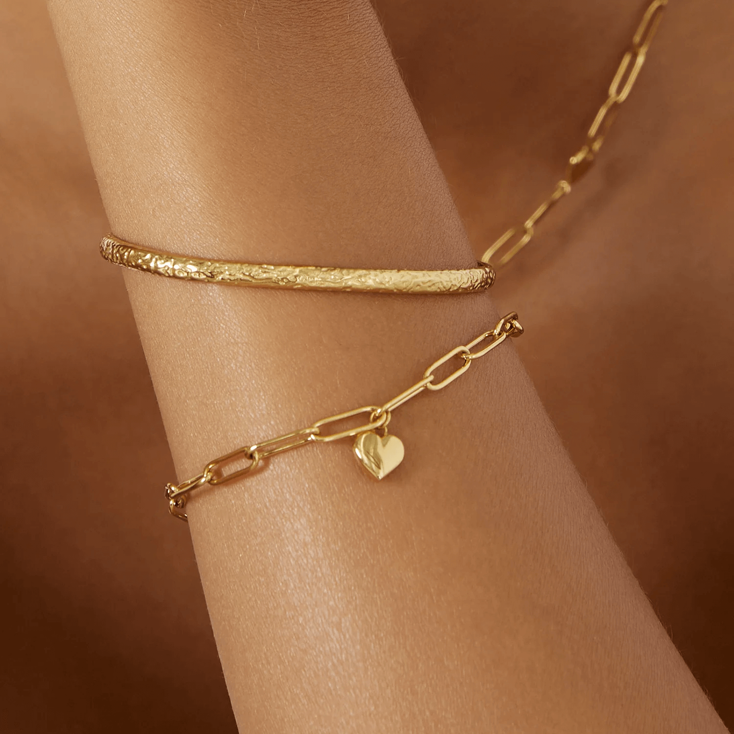 model wearing Gold link bracelet with a heart