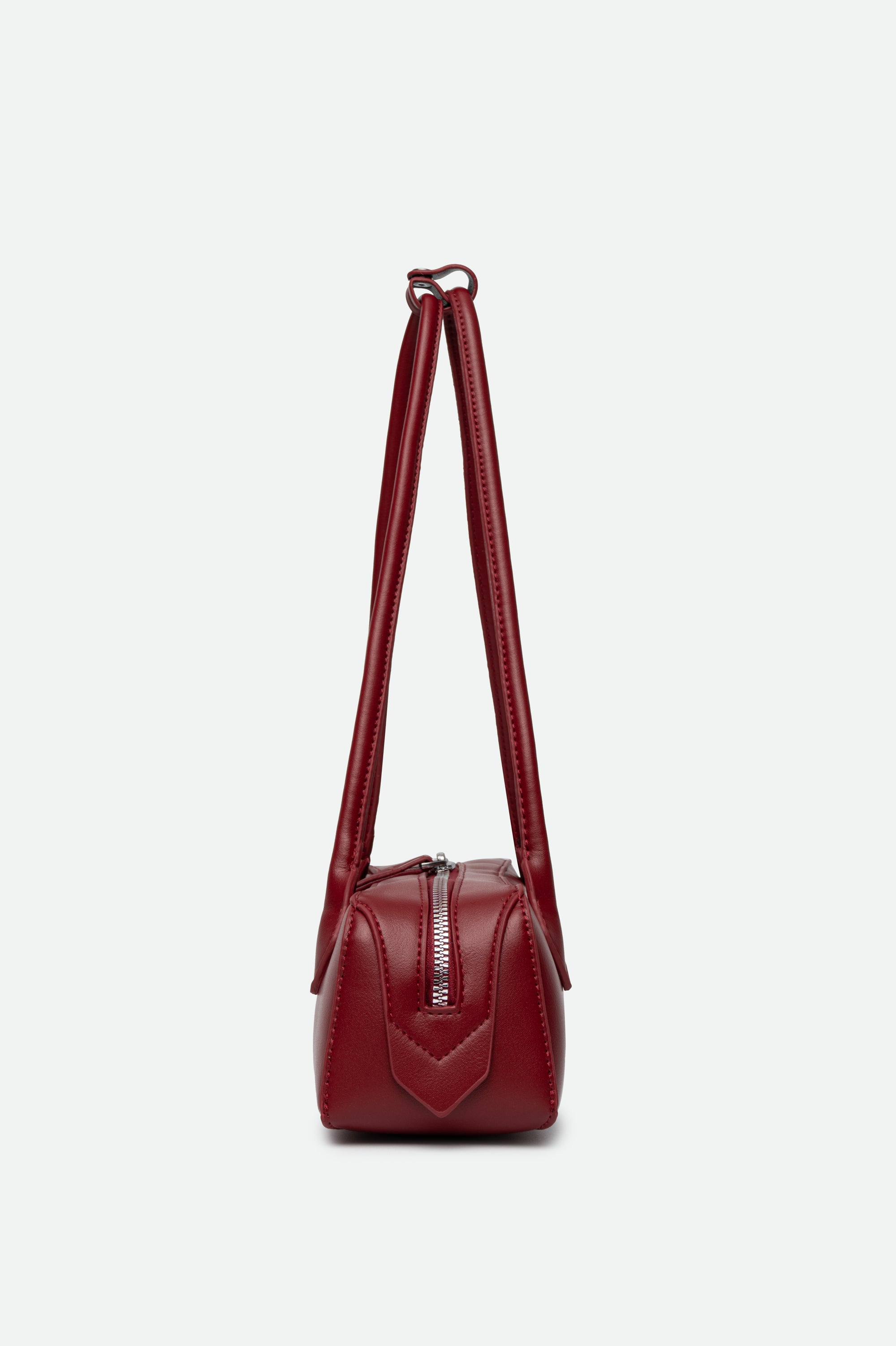Red handbag with a strap on a white background