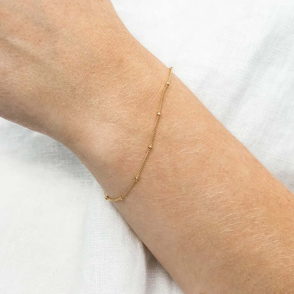 A model wearing gold chain bracelet