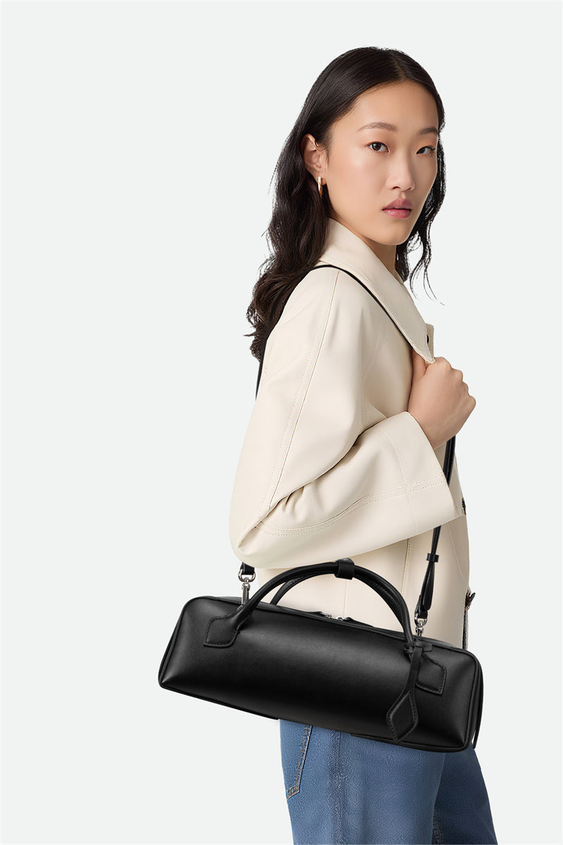 Woman holding a black handbag against a white background