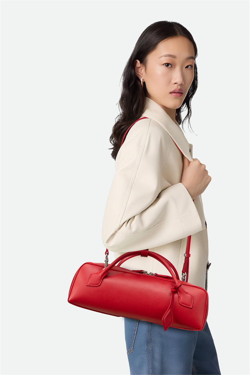 Woman holding a red handbag against a white background