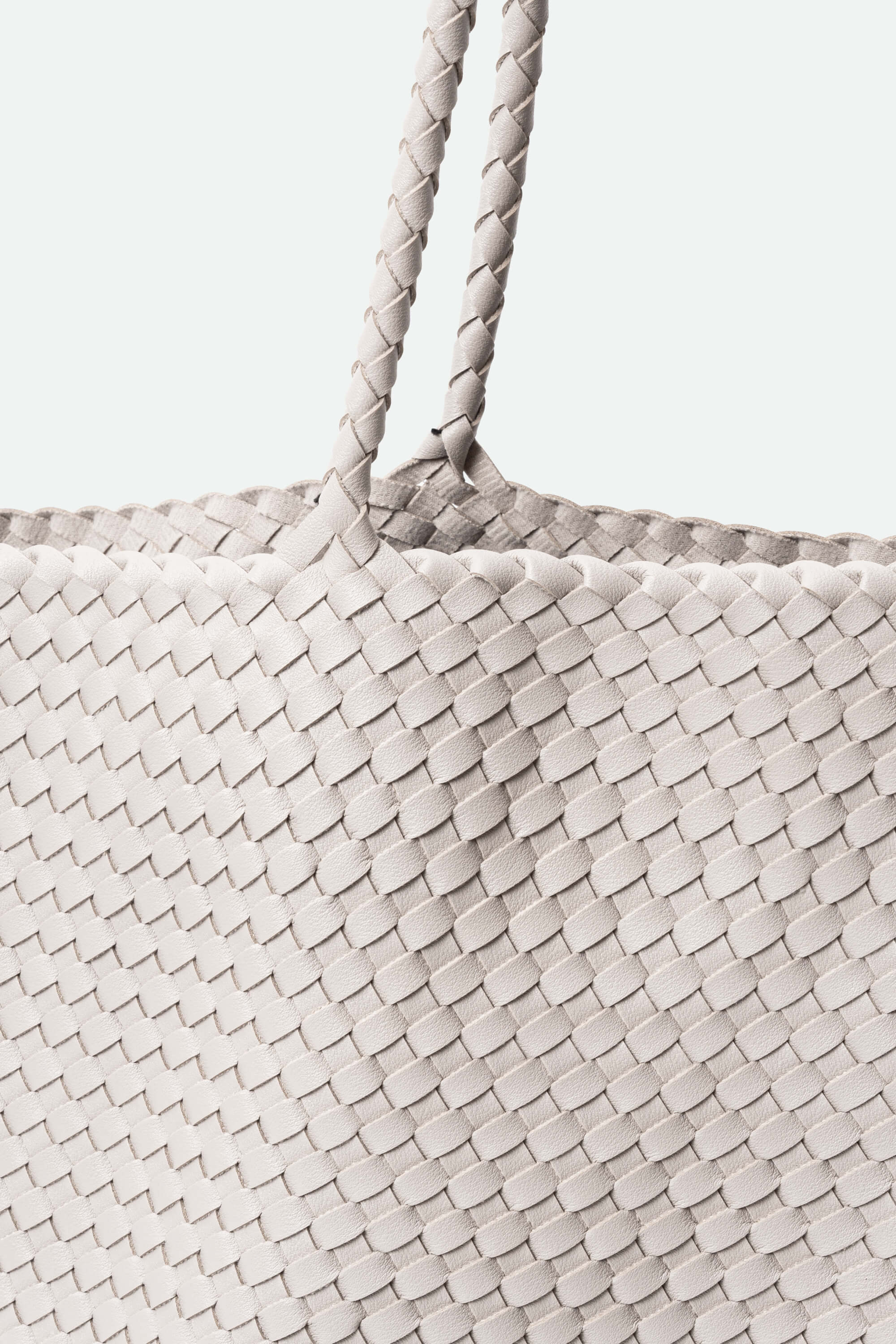 a large woven handbag against a white background