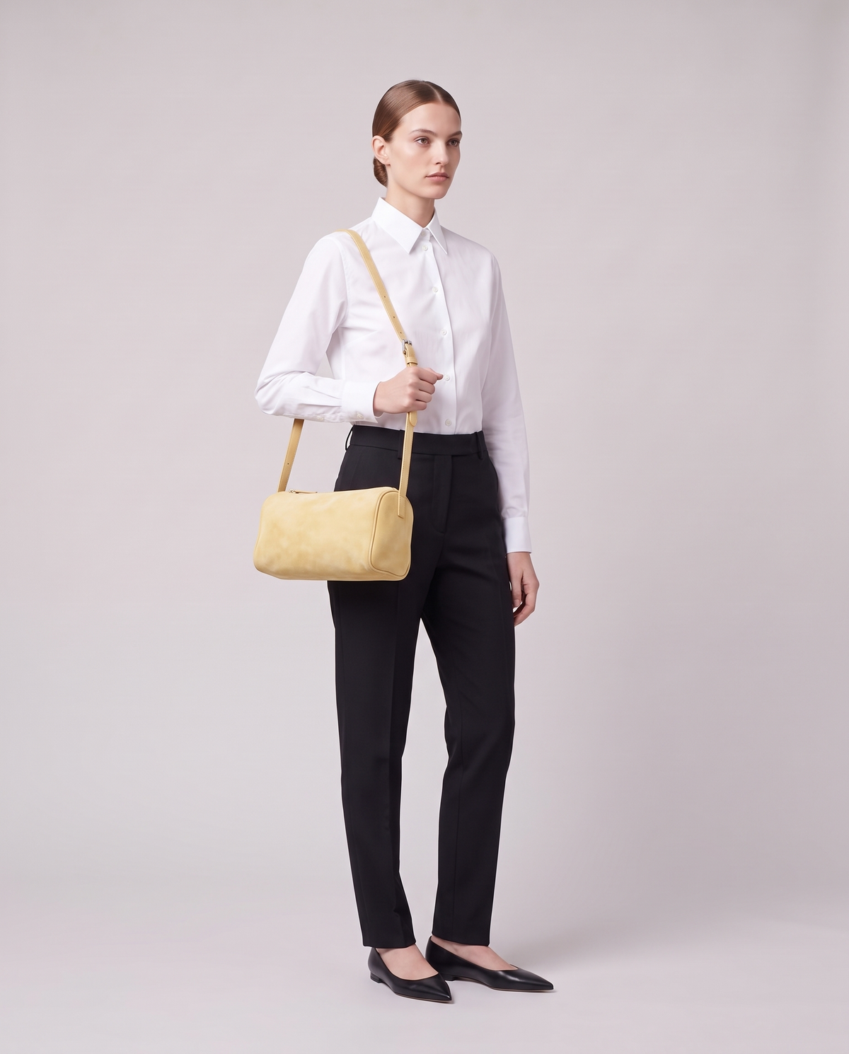 Model carrying the Alba barrel shoulder bag in Butter suede on the shoulder