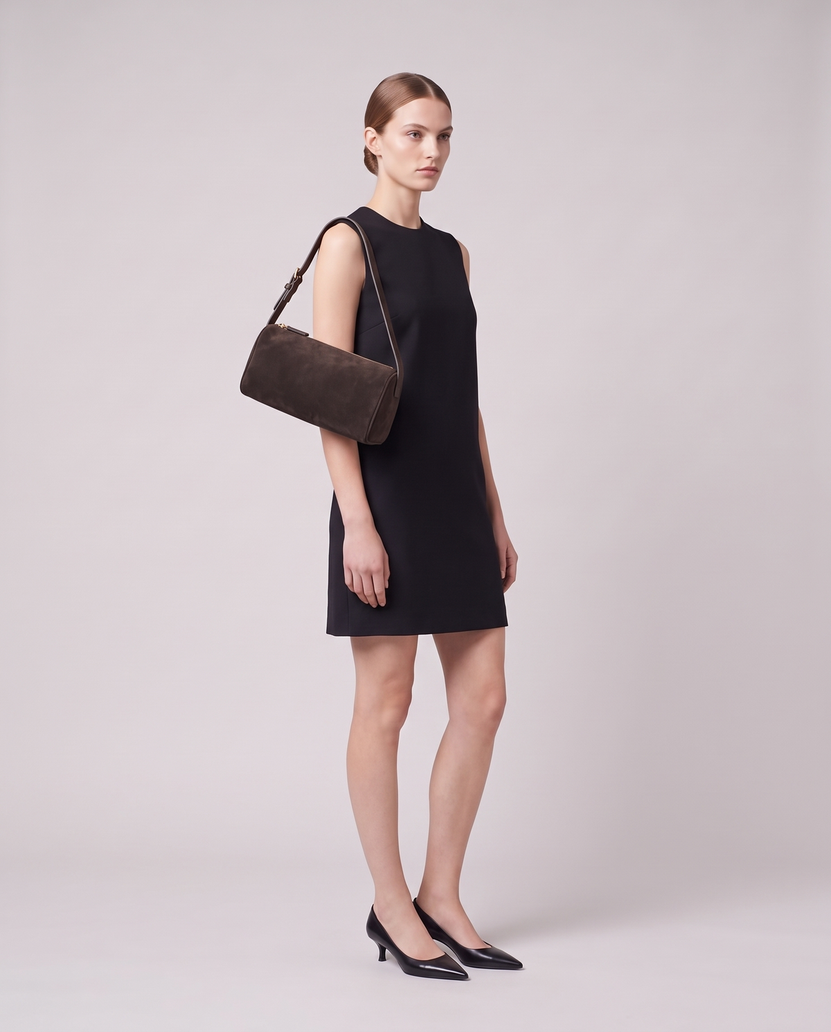 Model carrying the Alba barrel shoulder bag in Espresso suede on the shoulder