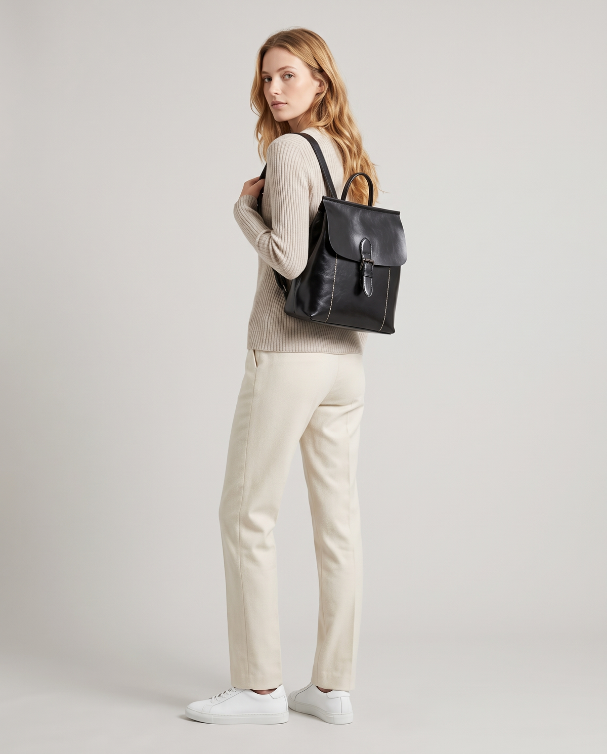 Ambler waxed leather backpack in Black – model wearing it on her back, full length