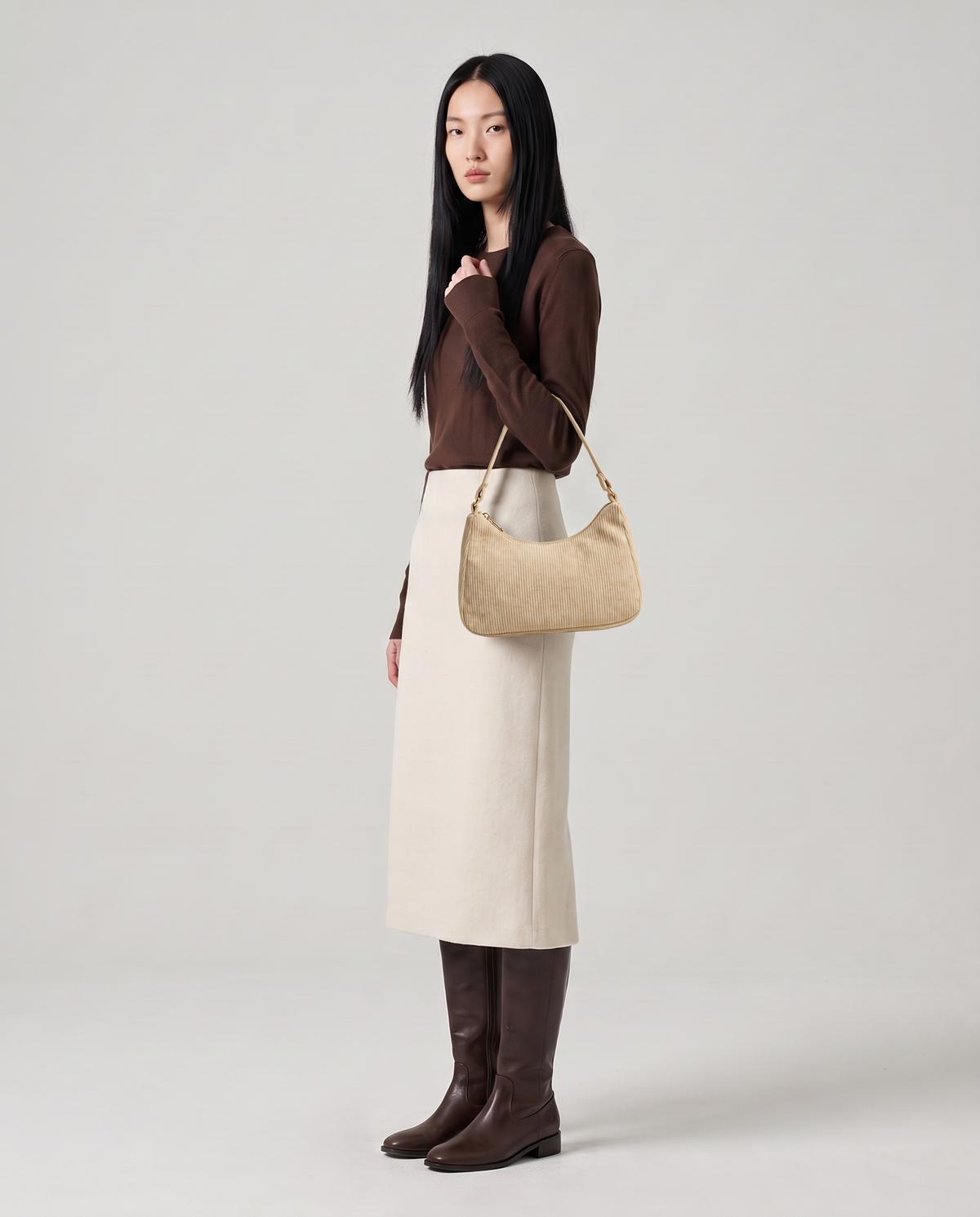 Aura corduroy shoulder bag in Beige – model wearing it on her shoulder, full length