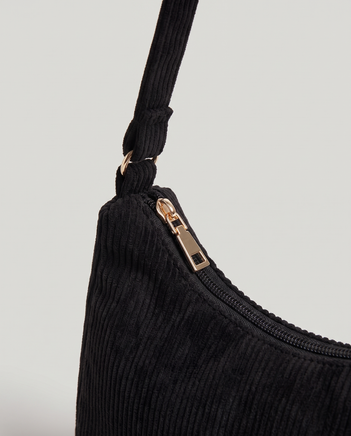Aura corduroy shoulder bag in Black – close-up of the corduroy, zip and strap fitting