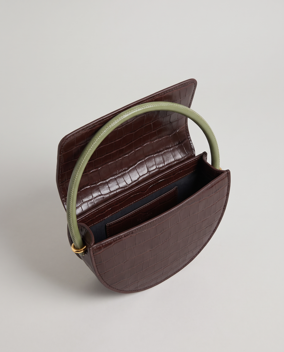 Crescent croc-embossed half-moon bag in Brown – flap open, showing the lined interior