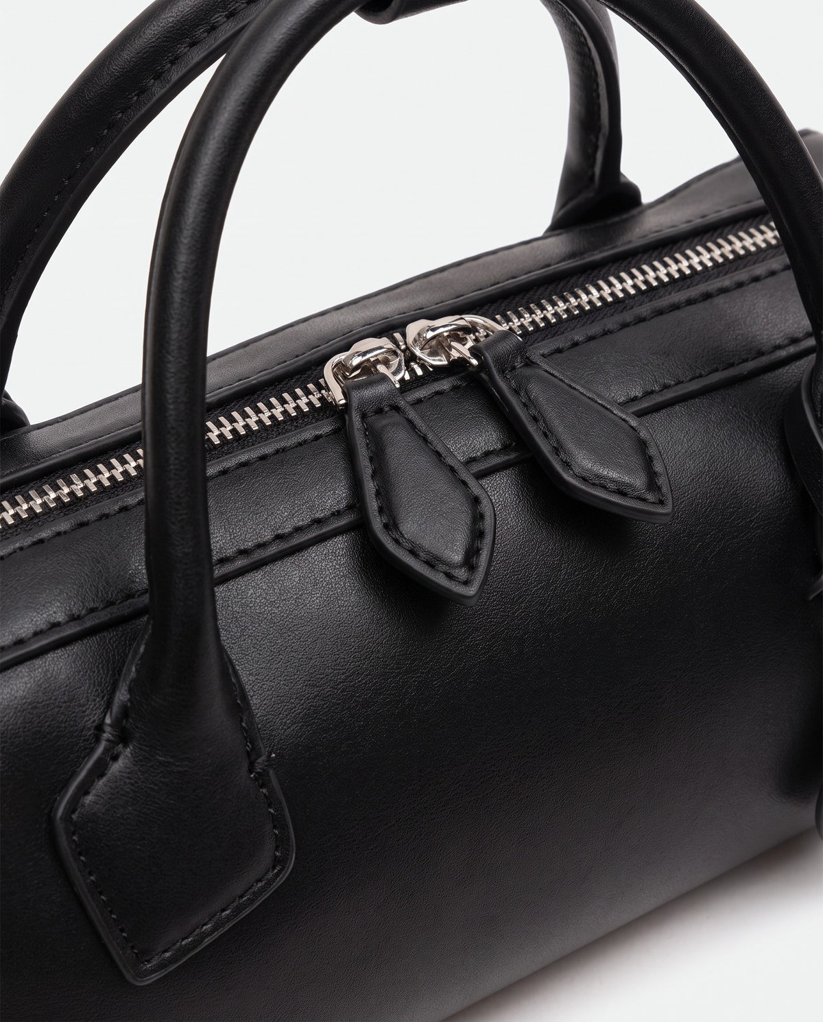 Curve leather barrel bag in Black – close-up of the handle and zip pulls