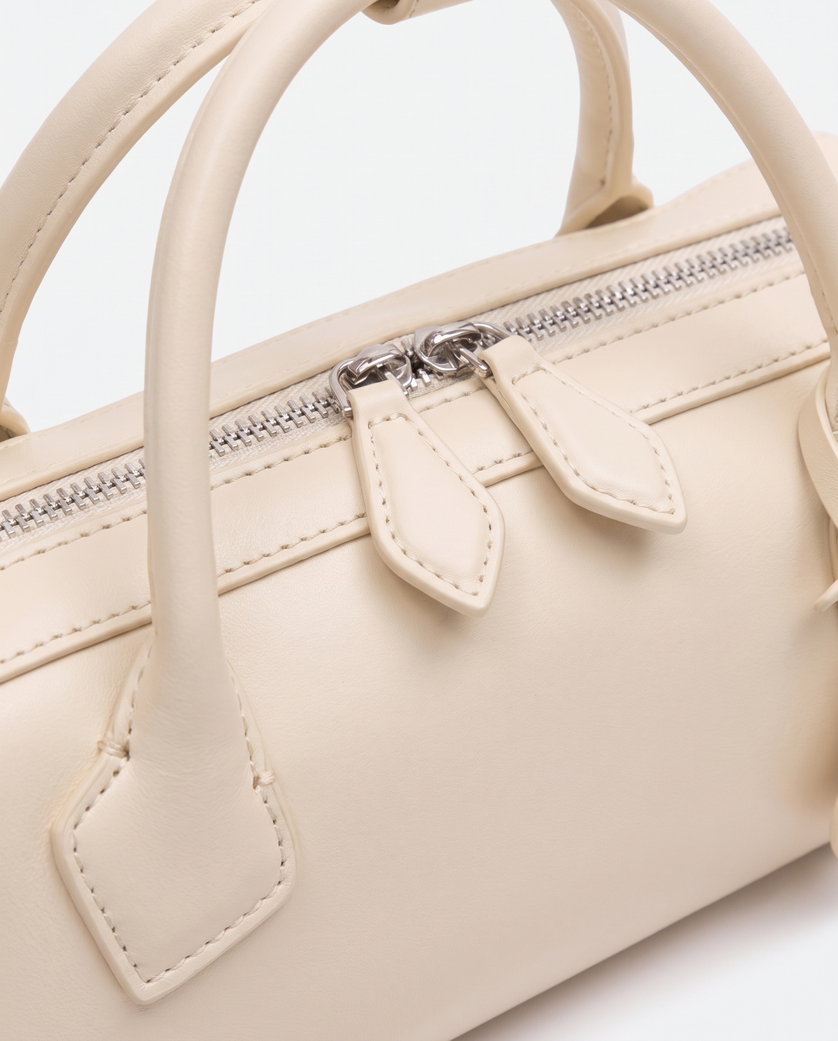 Curve leather barrel bag in Ivory – close-up of the handle and zip pulls