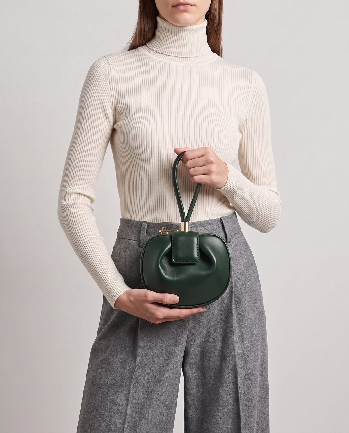 Dumpling Mini leather top-handle bag in Green – model holding it at the waist