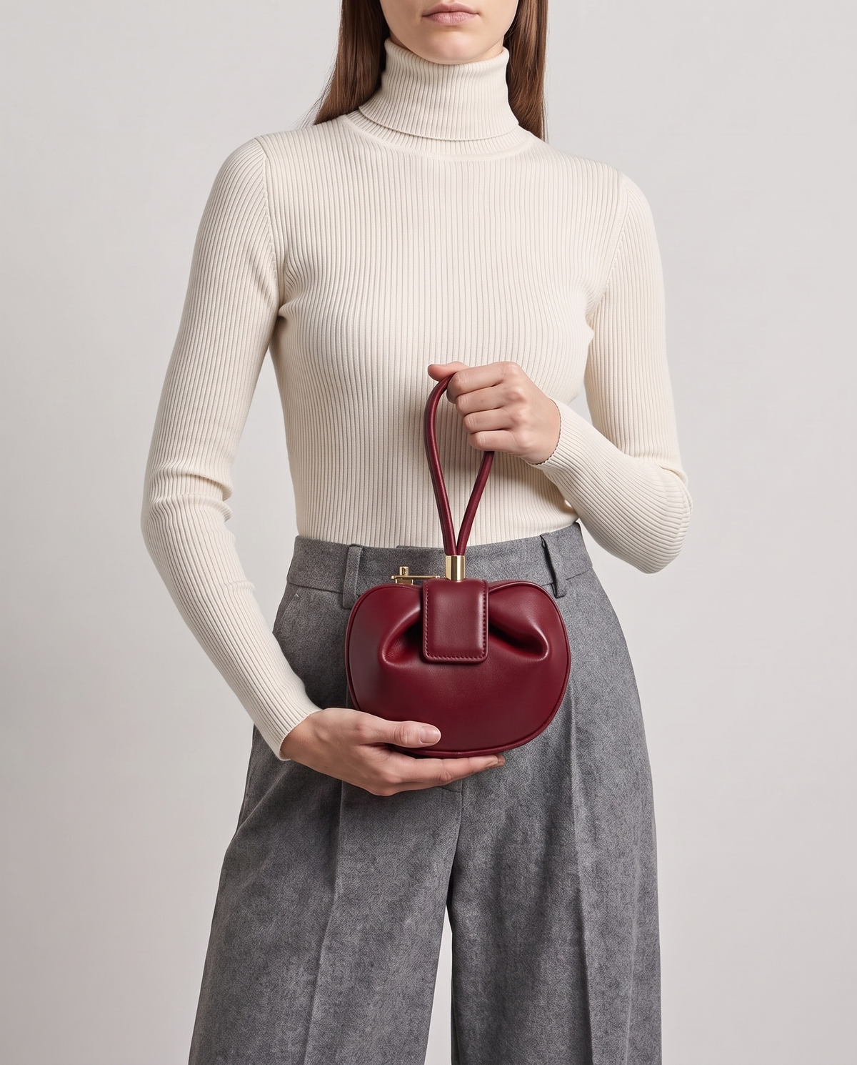 Dumpling Mini leather top-handle bag in Red – model holding it at the waist
