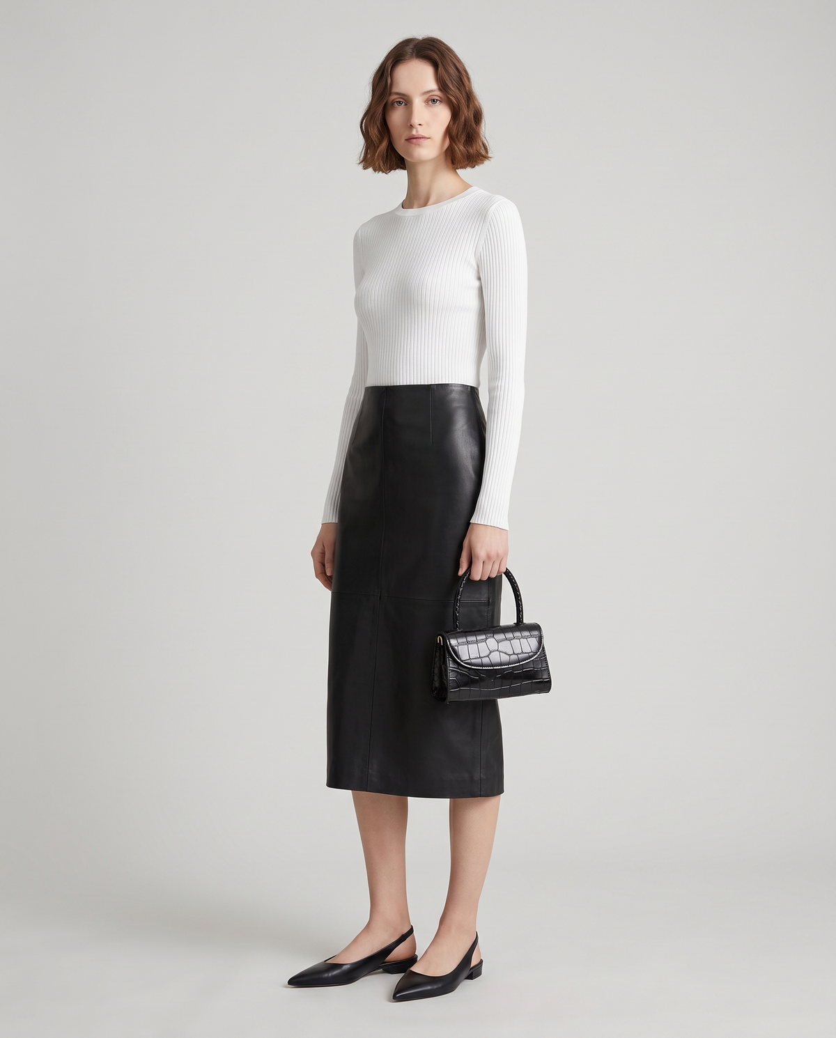 Fern mini croc top-handle bag in Black – model holding it by the top handle, full length