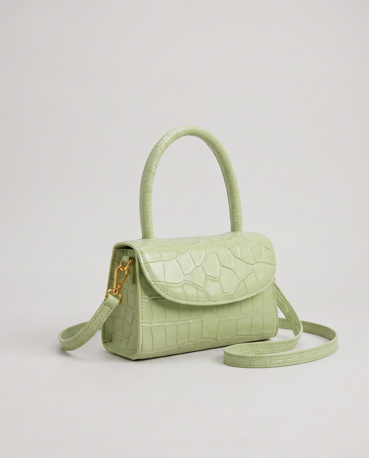 Fern mini croc top-handle bag in Pistachio – three-quarter view with the crossbody strap
