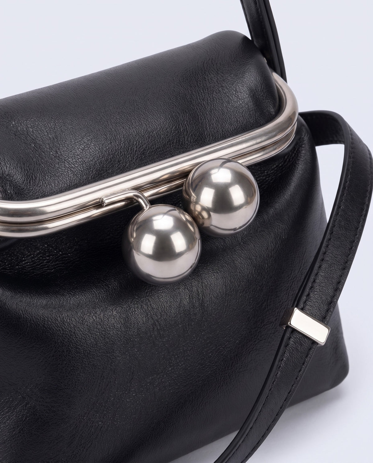 Silver kiss-lock clasp detail on the Garda frame bag in Black