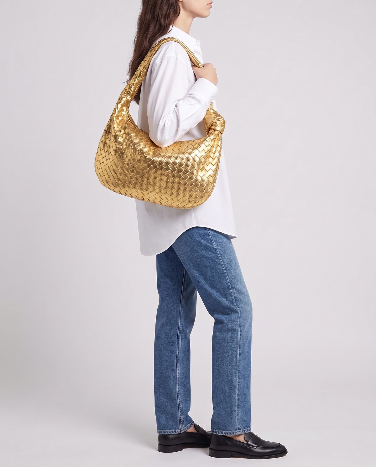 Knot Maxi woven leather shoulder bag in Gold – model carrying it on the shoulder