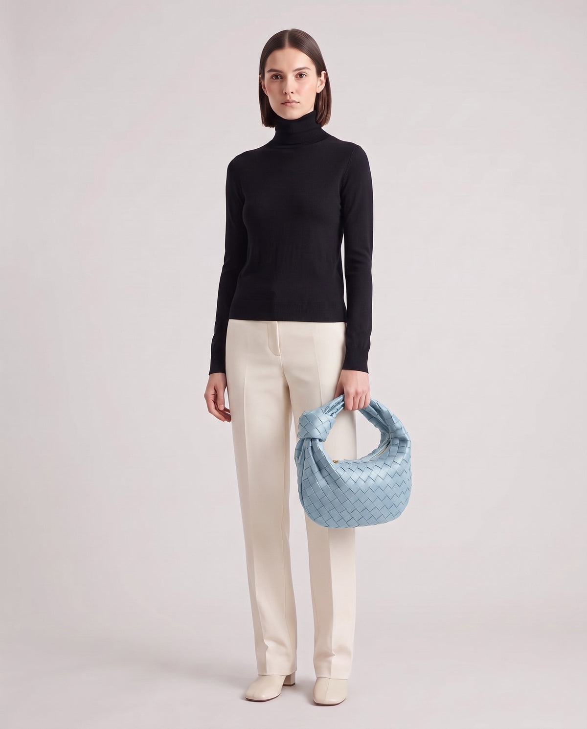 Knot Midi woven leather bag in Blue – model holding it, full length