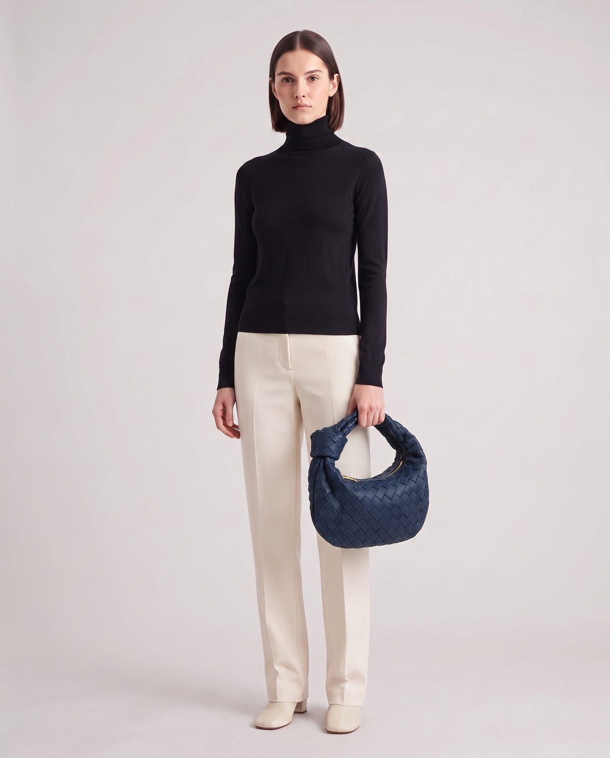 Knot Midi woven leather bag in Navy – model holding it, full length