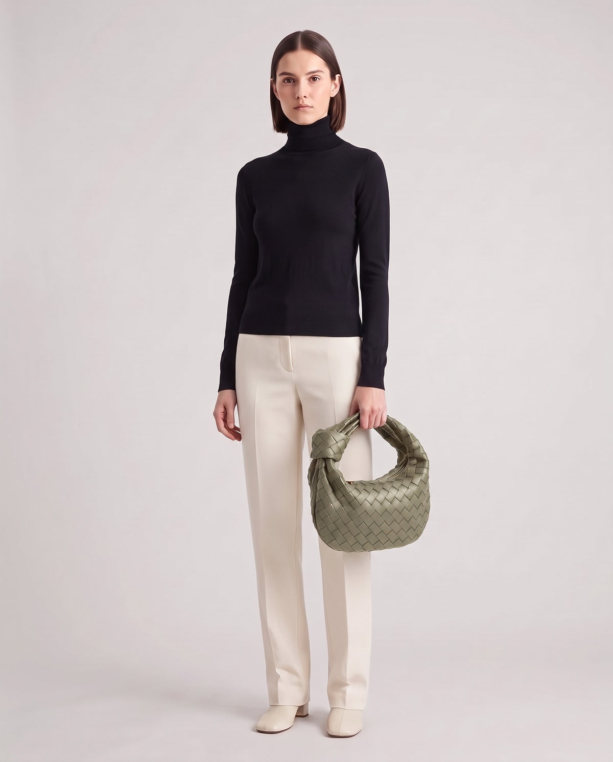 Knot Midi woven leather bag in Sage – model holding it, full length