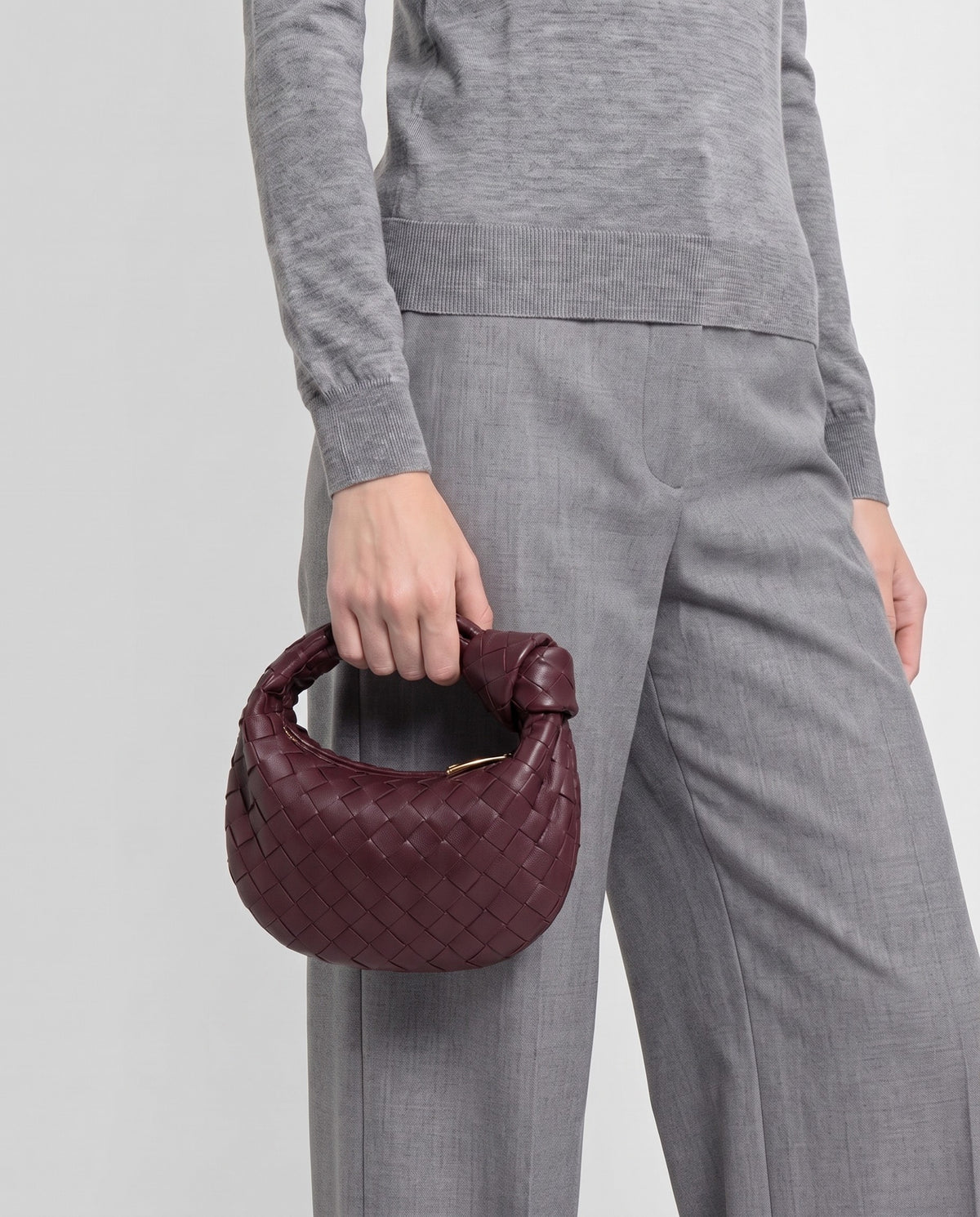 Knot Mini woven leather bag in Bordeaux – model carrying it