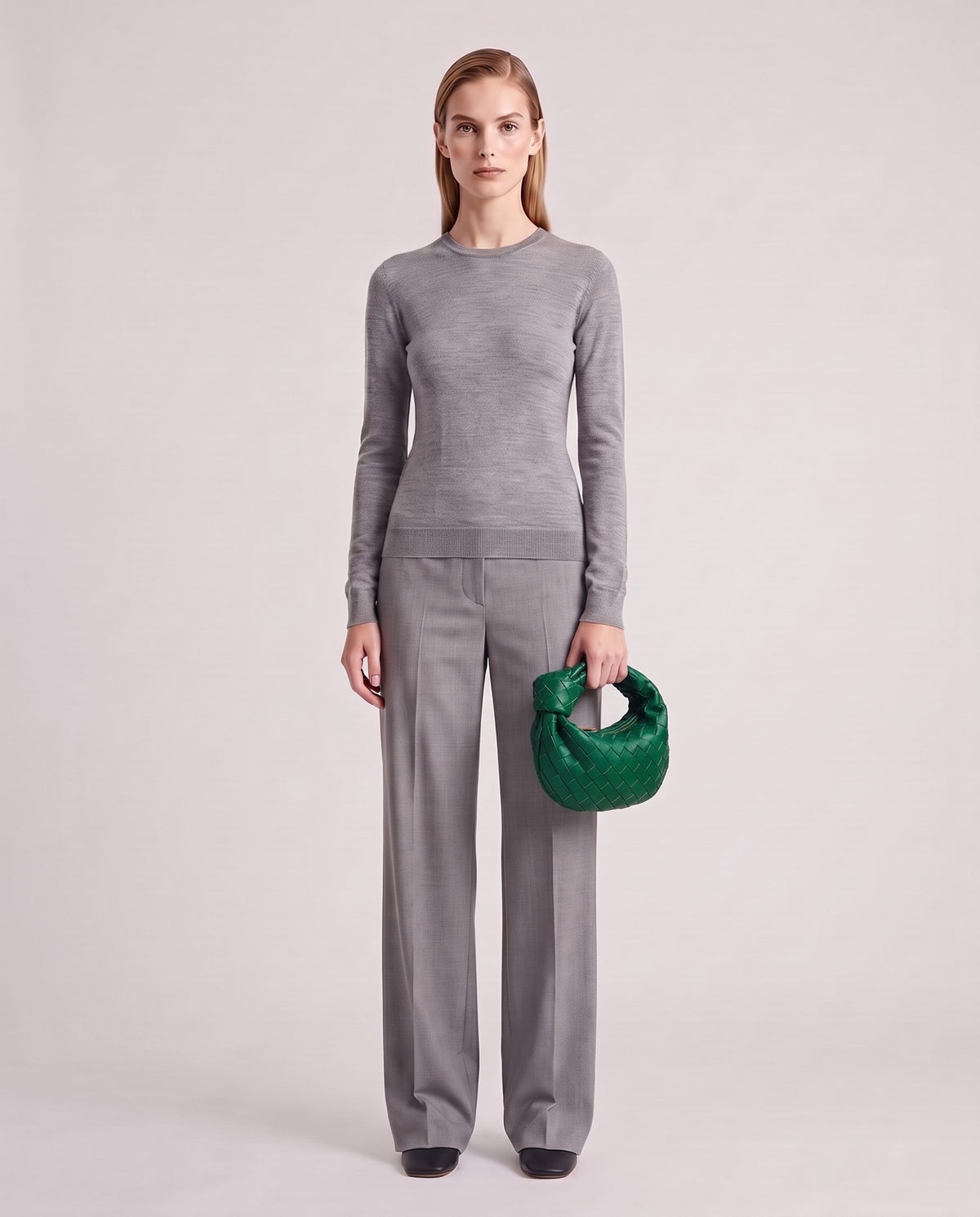 Knot Mini woven leather bag in Emerald – model holding it, full length
