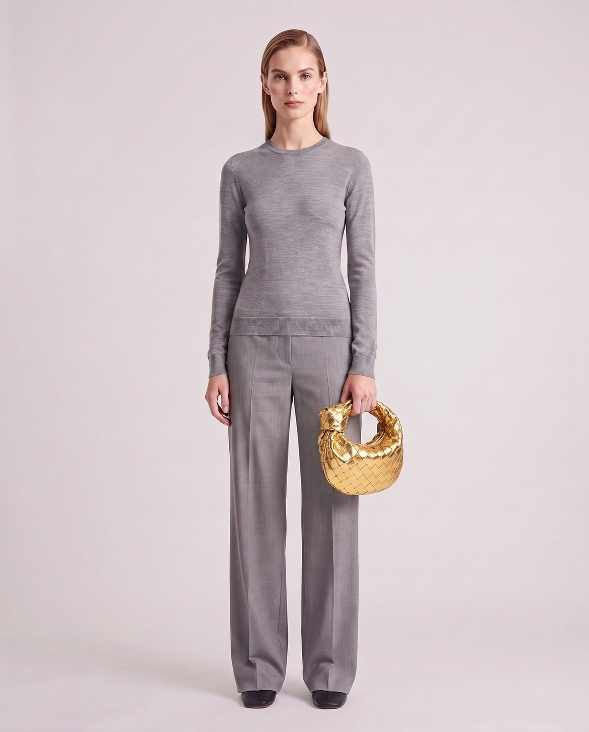 Knot Mini woven leather bag in Gold – model holding it, full length