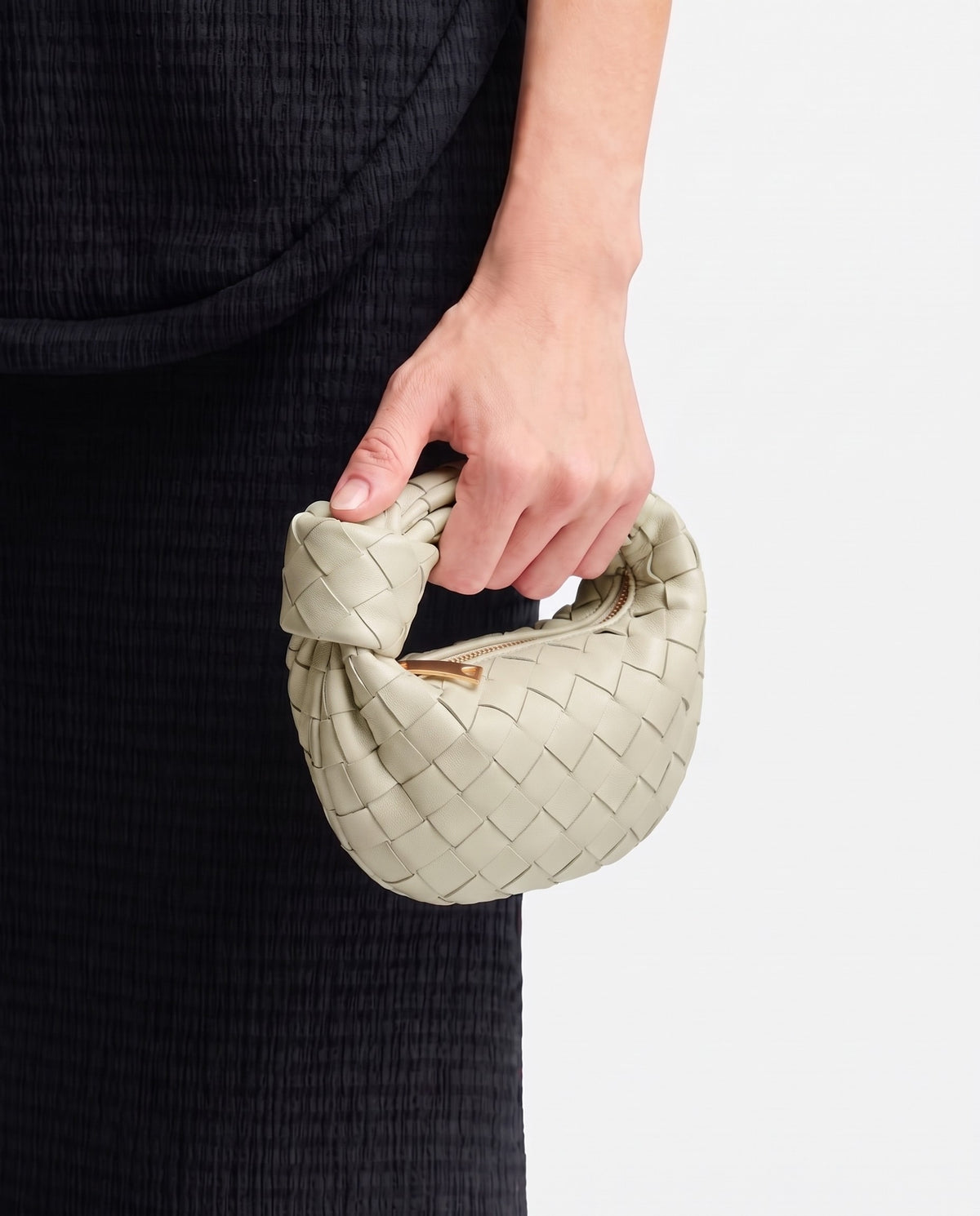 Knot Mini woven leather bag in Pistachio – held in the hand, showing true size