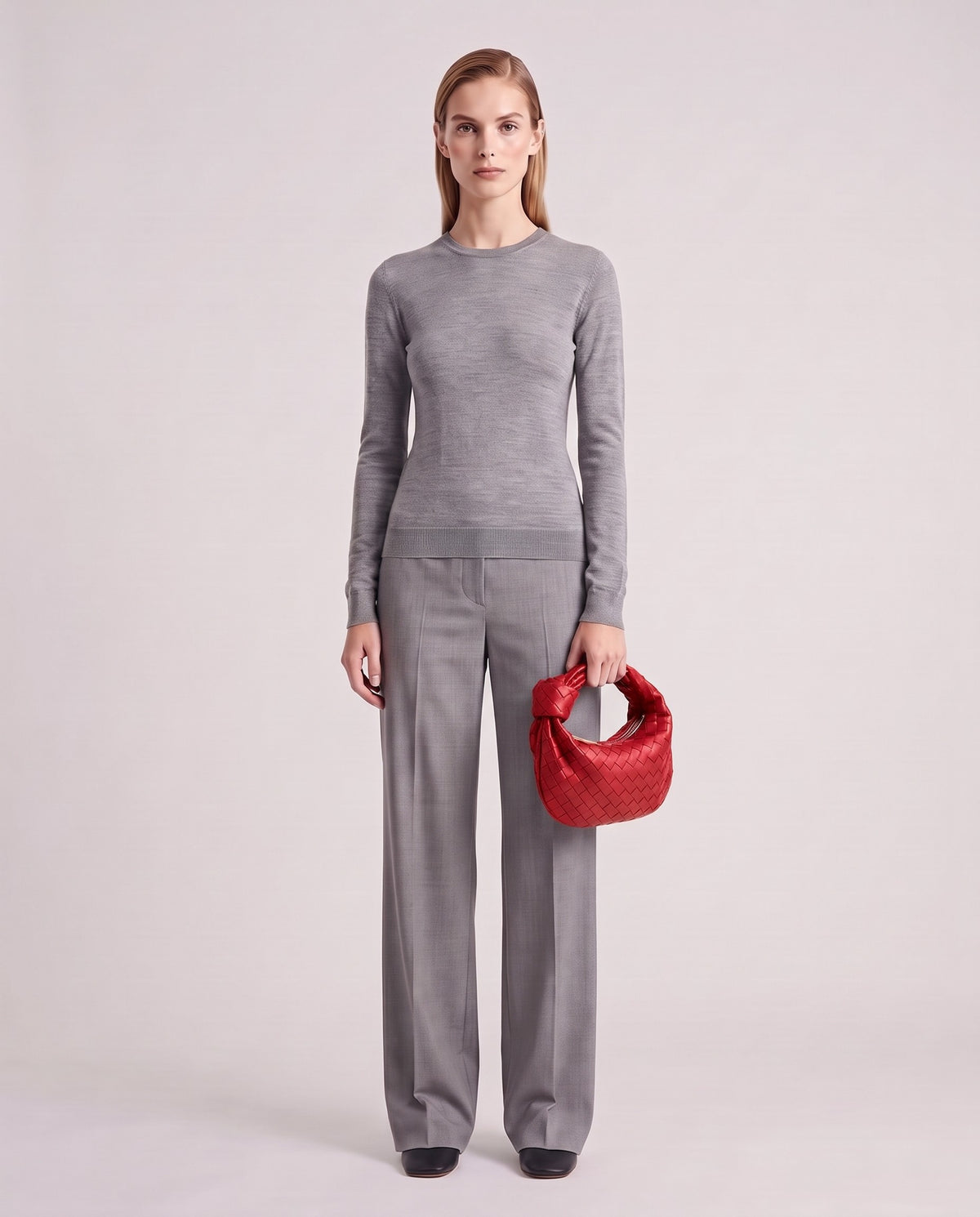 Knot Mini woven leather bag in Scarlet – model holding it, full length