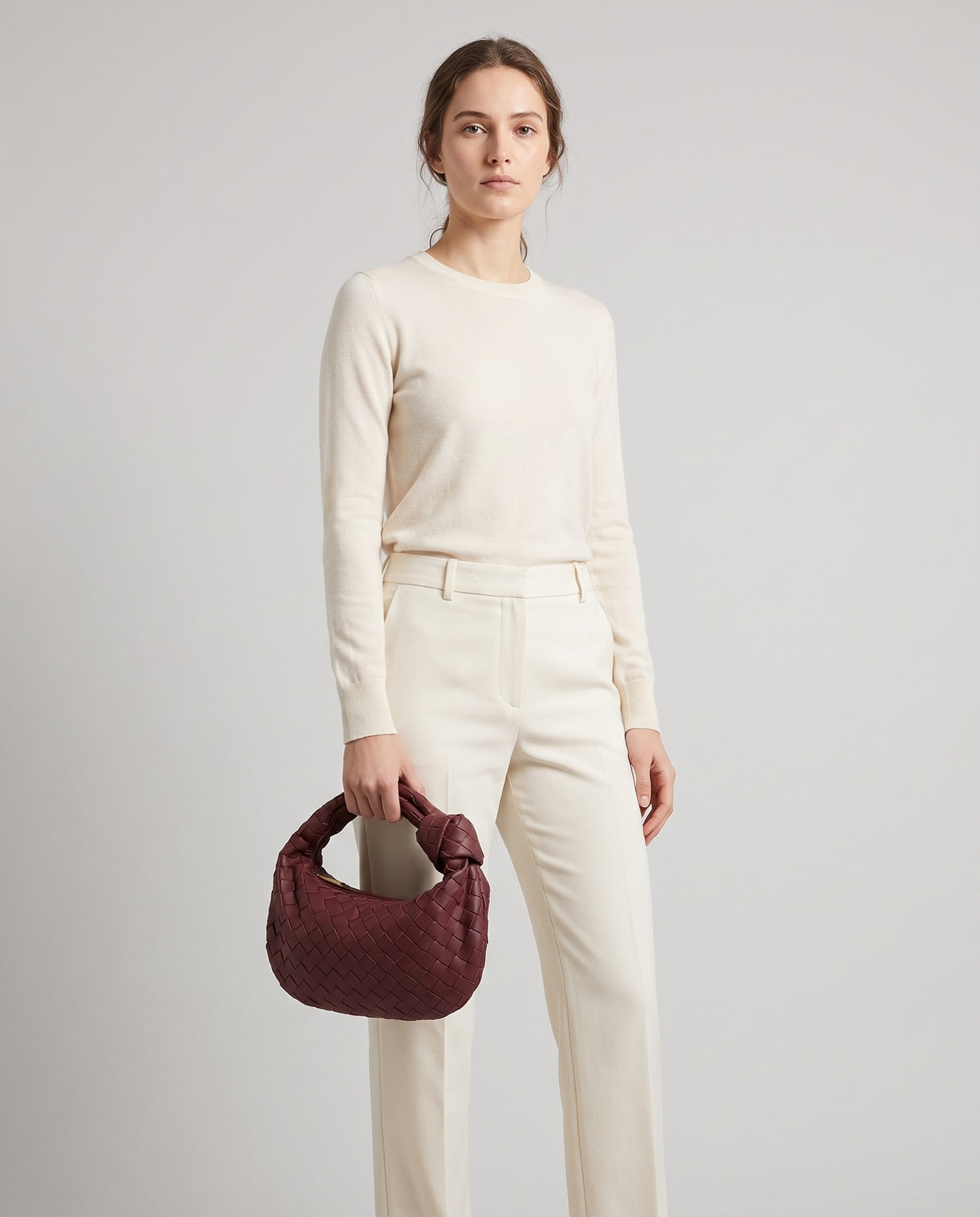 Knot Small woven leather bag in Bordeaux – model holding it, full length