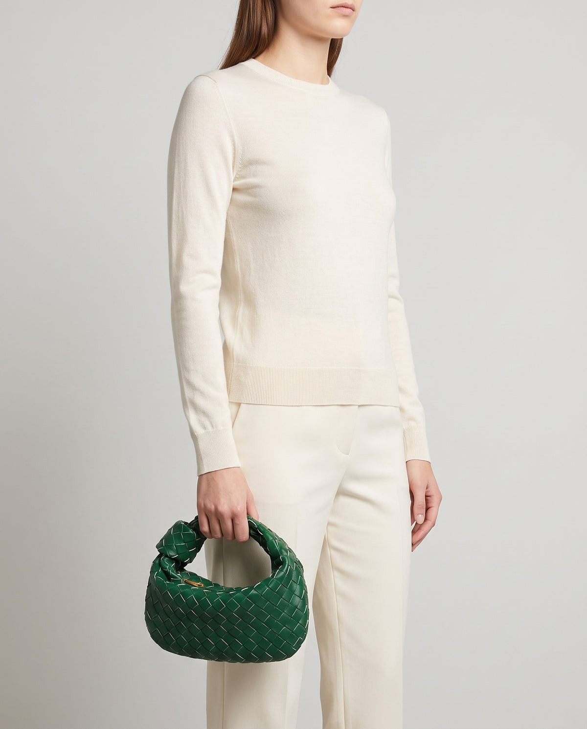 Knot Small woven leather bag in Green – model carrying it by the knotted handle