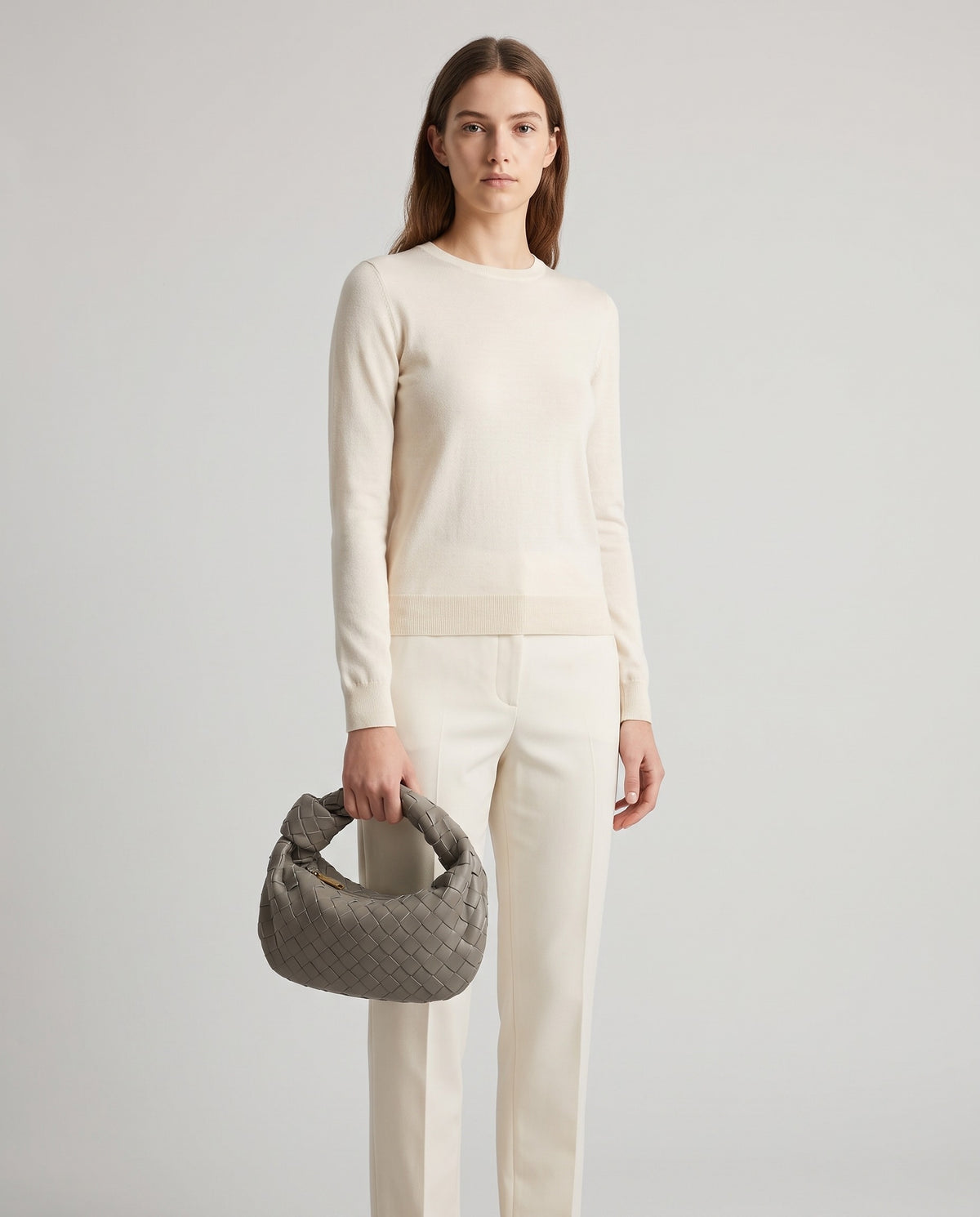 Knot Small woven leather bag in Stone – model holding it, full length