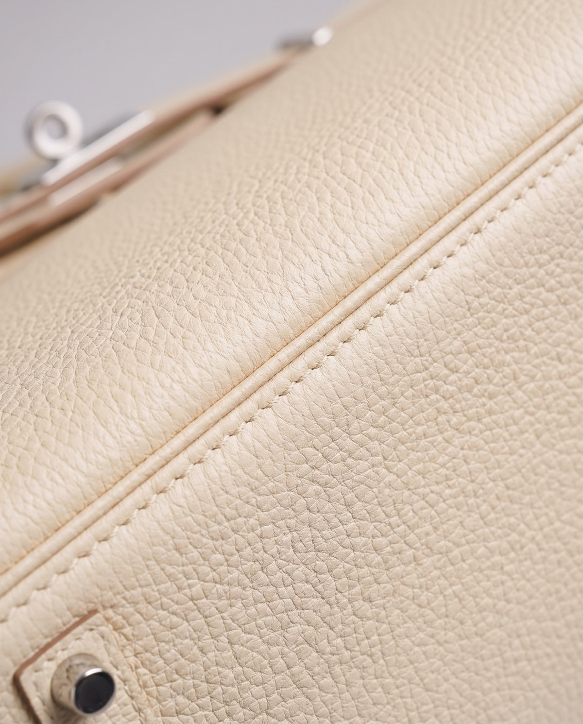 Lock Large leather top-handle bag in Cream – close-up of the pebbled leather and stitching