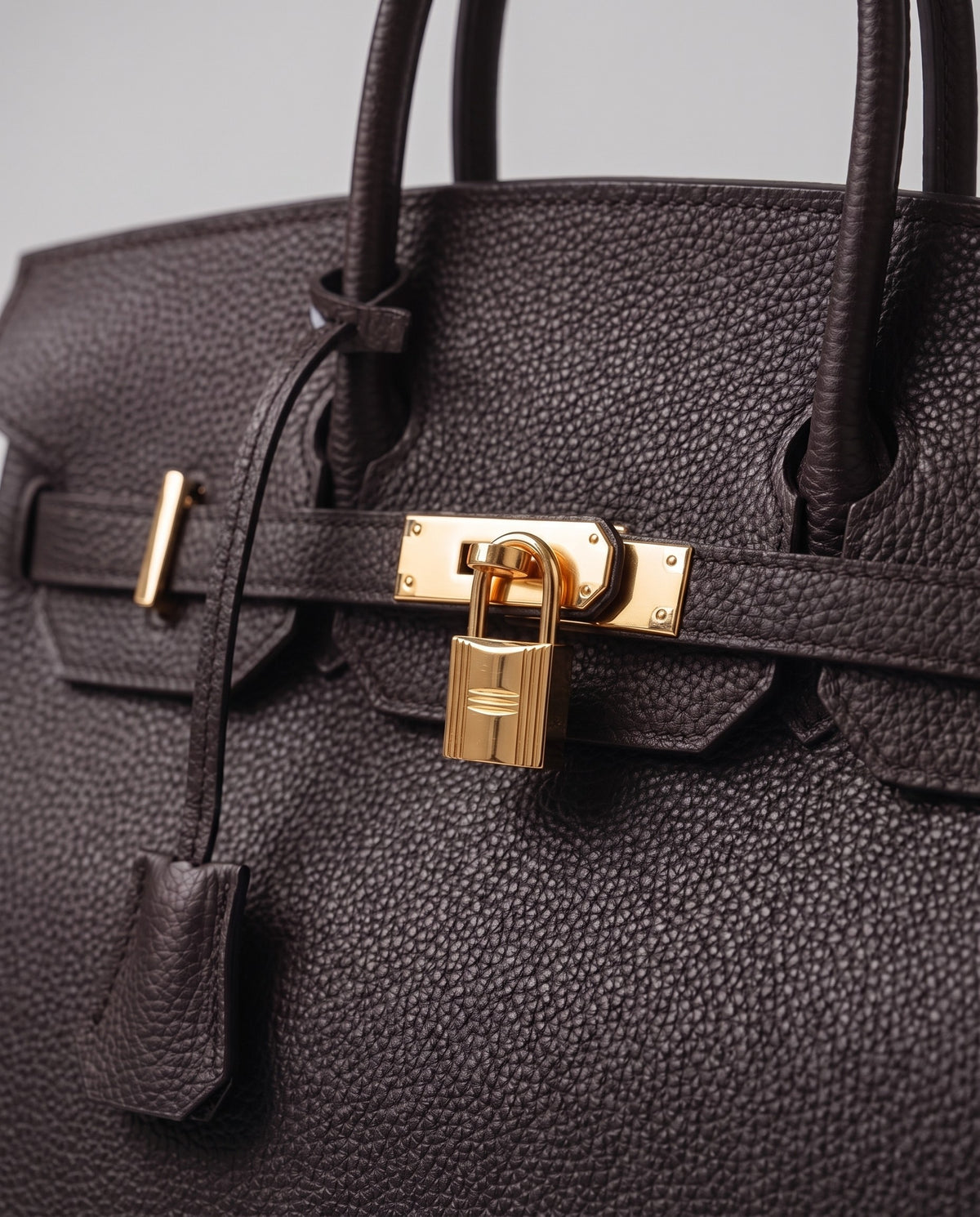 Lock Large leather top-handle bag in Espresso – close-up of the gold turn-lock and padlock