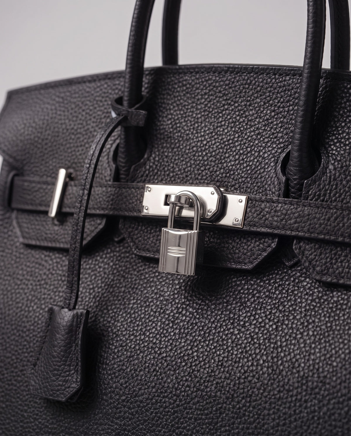Lock Large leather top-handle bag in Onyx – close-up of the silver turn-lock and padlock