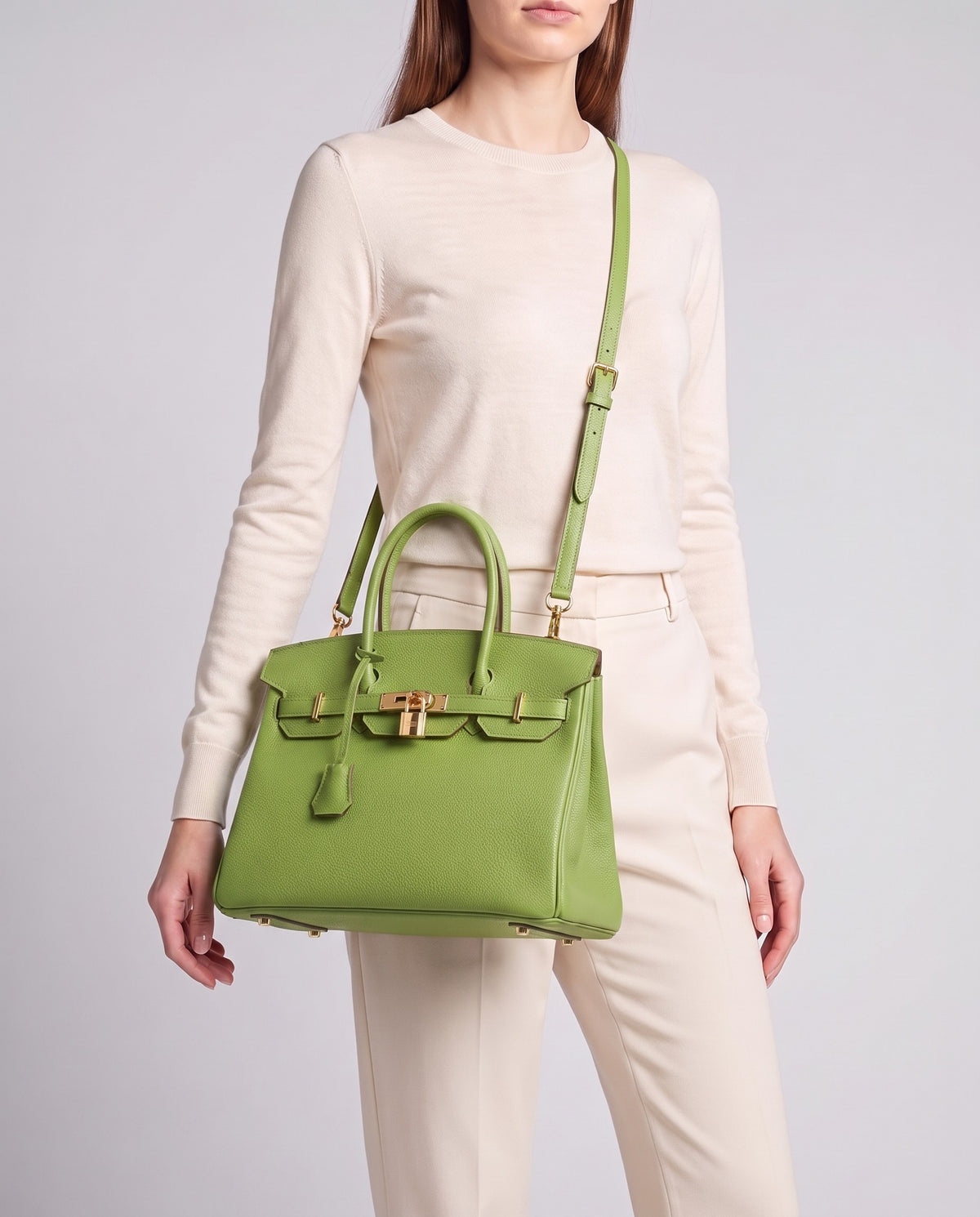 Lock Medium leather top-handle bag in Avocado – model wearing it crossbody on the detachable shoulder strap