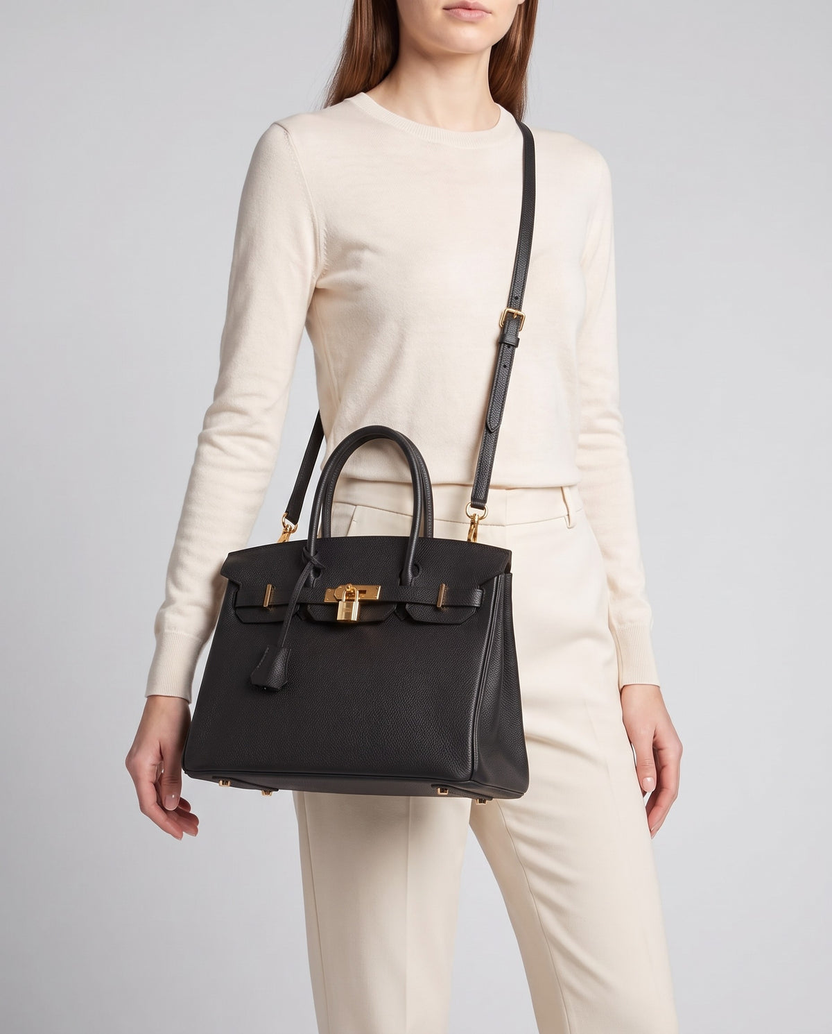 Lock Medium leather top-handle bag in Black – model wearing it crossbody on the detachable shoulder strap