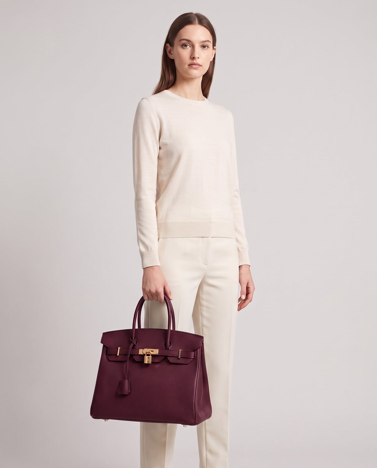 Lock Medium leather top-handle bag in Bordeaux – model holding it, full length