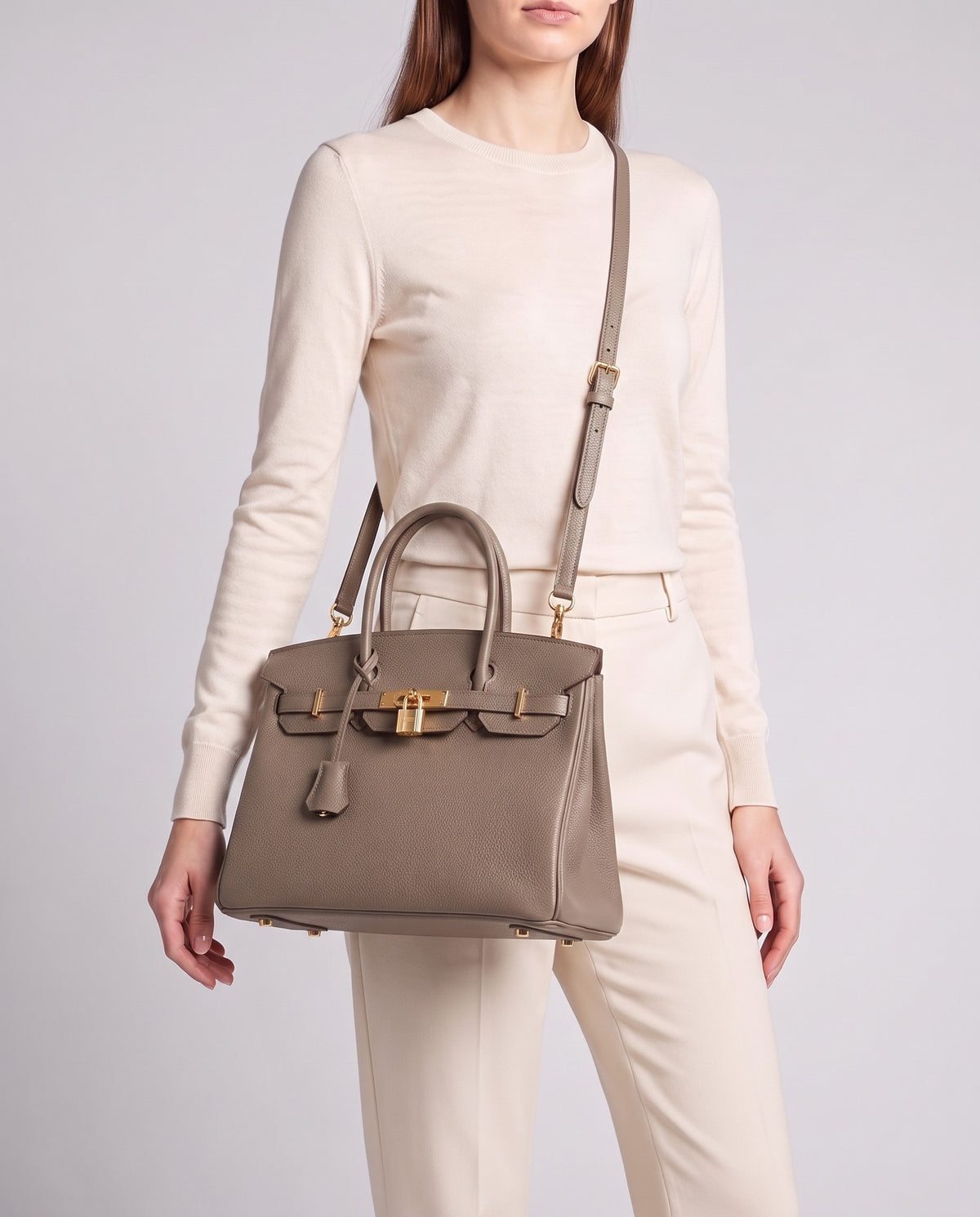 Lock Medium leather top-handle bag in Taupe – model wearing it crossbody on the detachable shoulder strap