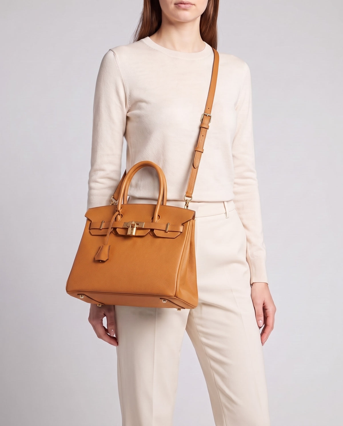 Lock Small leather top-handle bag in Caramel – model wearing it crossbody on the detachable shoulder strap