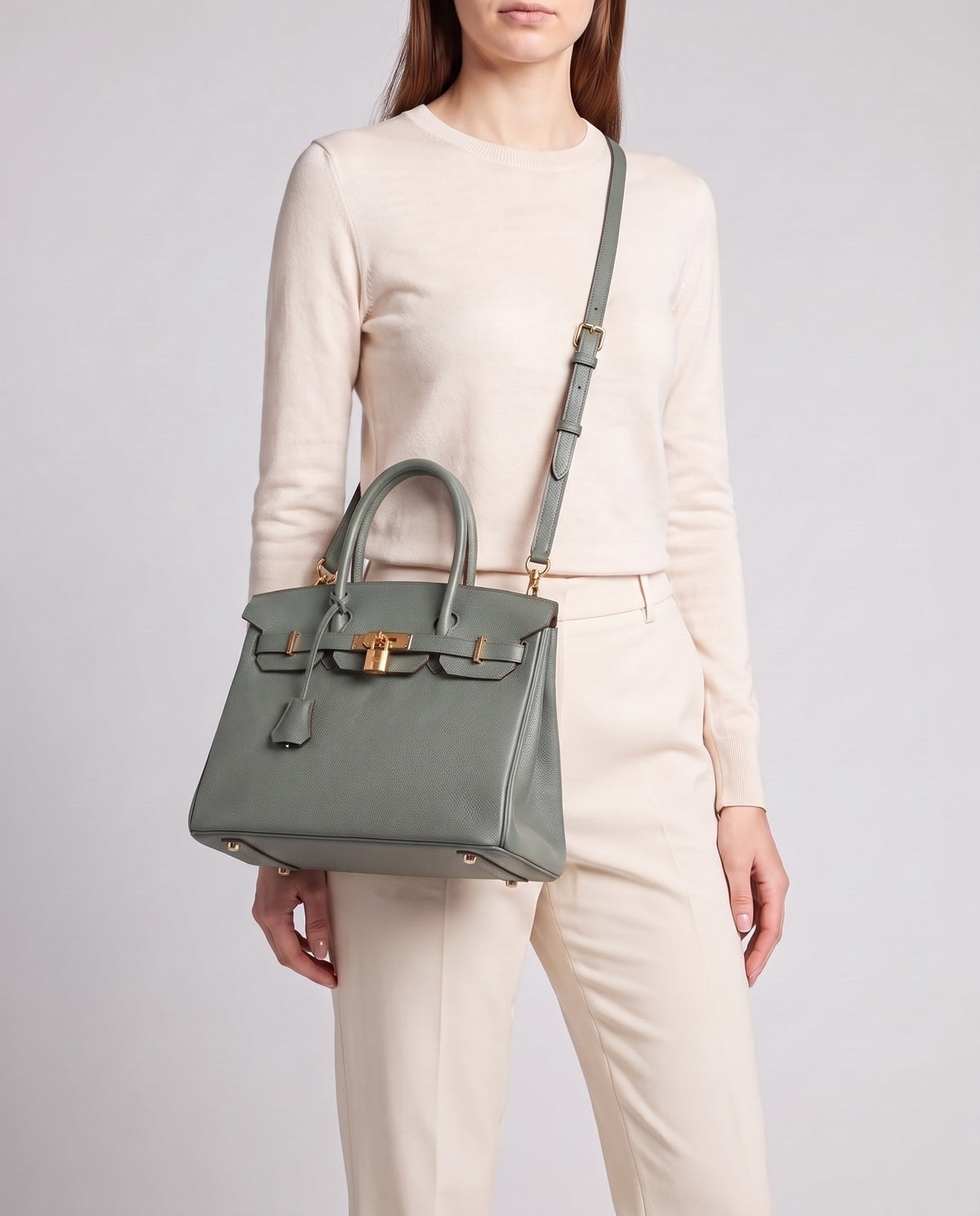 Lock Small leather top-handle bag in Celadon – model wearing it crossbody on the detachable shoulder strap