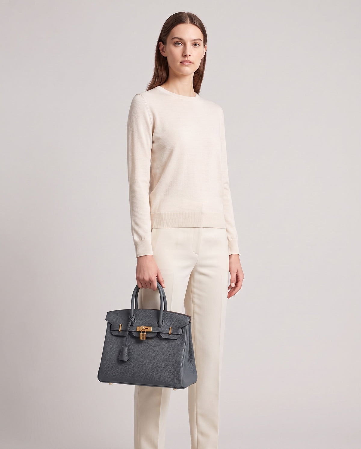 Lock Small leather top-handle bag in Charcoal – model holding it, full length