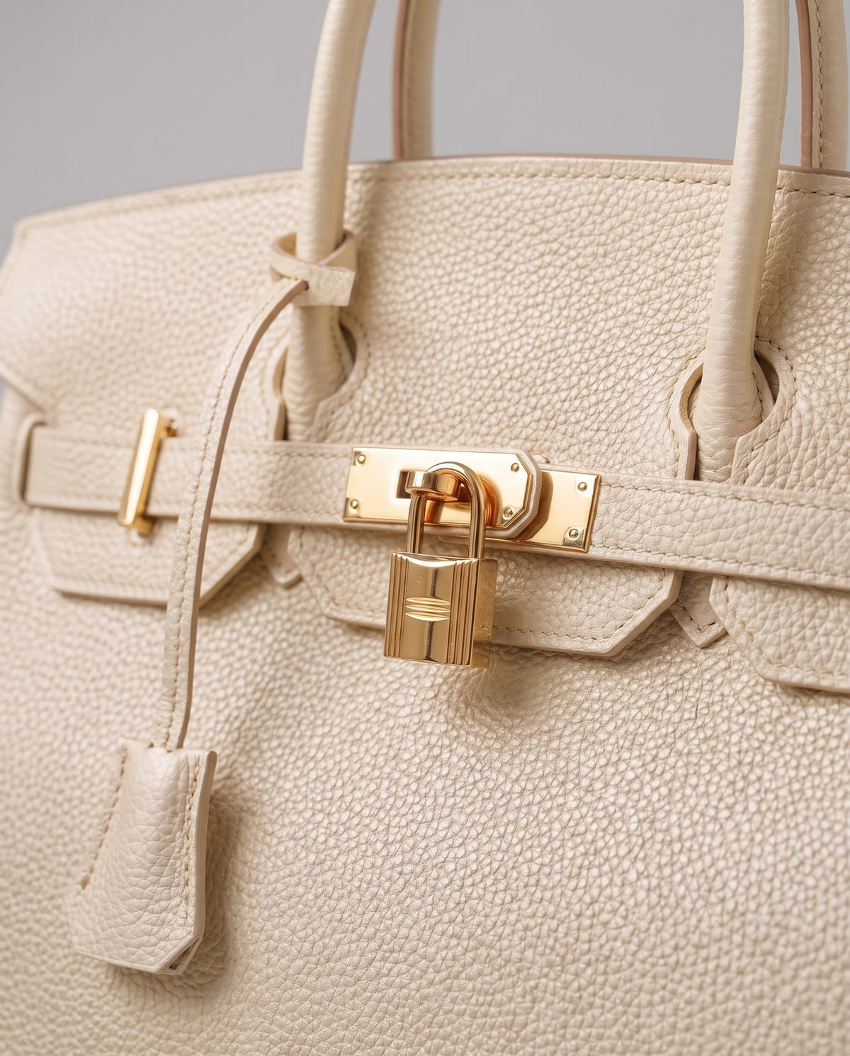Lock Small leather top-handle bag in Cream – close-up of the gold turn-lock and padlock